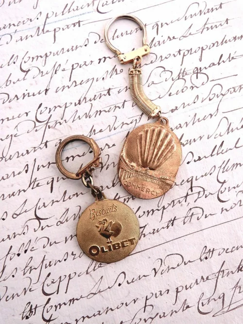Oude Franse vintage sleutelhanger "Madeleines de la Cloche d'Or"