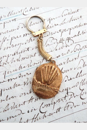 Oude Franse vintage sleutelhanger "Madeleines de la Cloche d'Or"