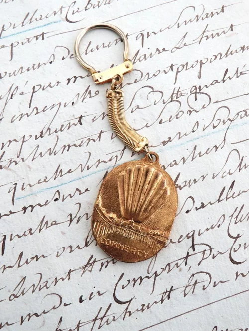 Oude Franse vintage sleutelhanger "Madeleines de la Cloche d'Or"