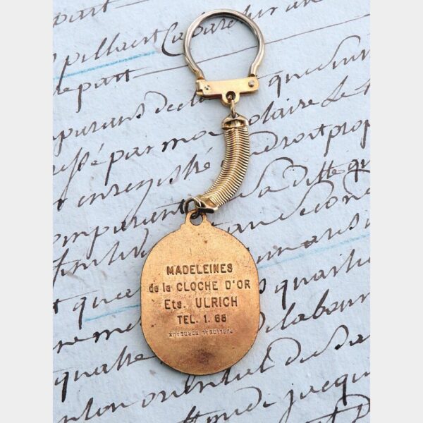Oude Franse vintage sleutelhanger "Madeleines de la Cloche d'Or"